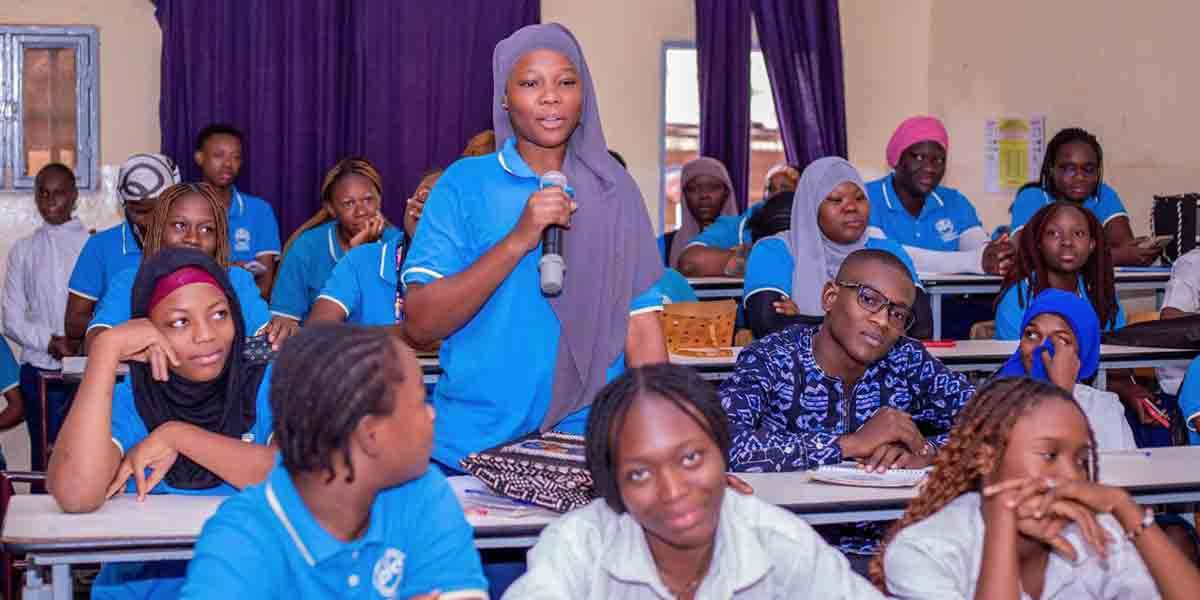 Étudiante intervenant en classe à l’ESC Ouagadougou pendant un cours avec des étudiants en formation de commerce.